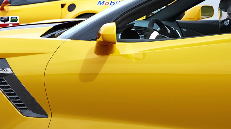 Close-up of a yellow 2018 Chevrolet Corvette side view mirror and door panel