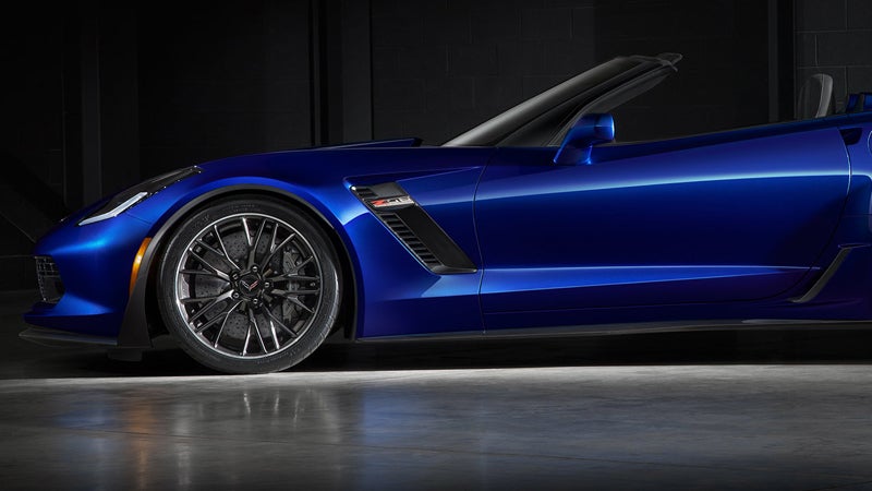 Low angle front side view of a blue 2018 Chevrolet Corvette convertible with black wheels