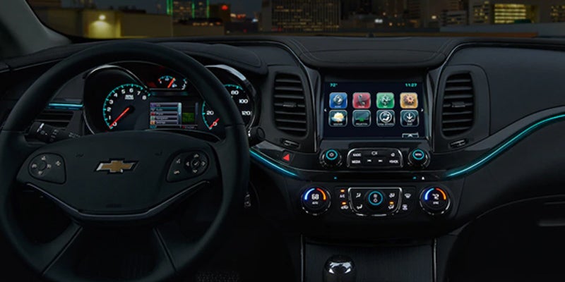 Close-up of the 2019 Chevrolet Impala dashboard at night, showing illuminated instrument cluster and Chevrolet MyLink infotainment system