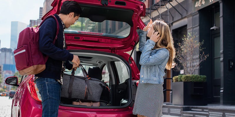 Couple loading luggage into a Chevrolet Spark
