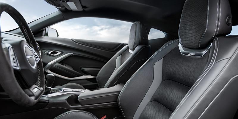 Interior view highlighting the Camaro’s front sport seats with contrast stitching and a premium performance-oriented cockpit.