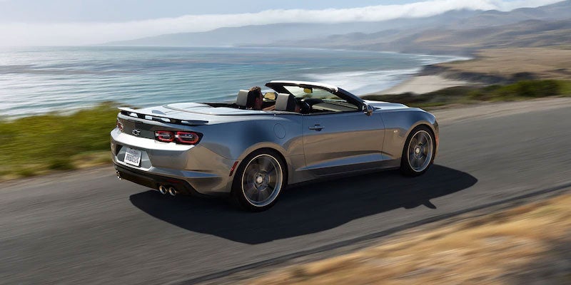 Chevrolet Camaro cruising along a scenic seaside road.