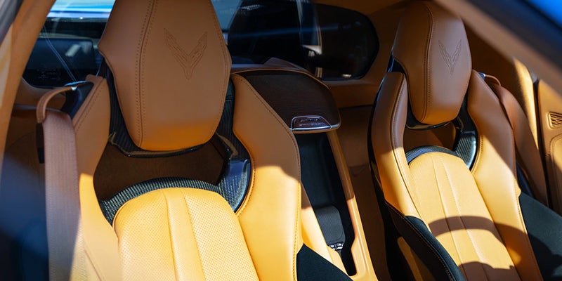 Close-up of tan leather bucket seats with Corvette logo embossed on the headrest