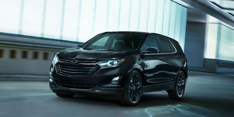 A blacked-out 2021 Chevy Equinox driving through a sleek urban tunnel at speed.