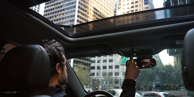 Man in Chevrolet Malibu opening sunroof with a switch