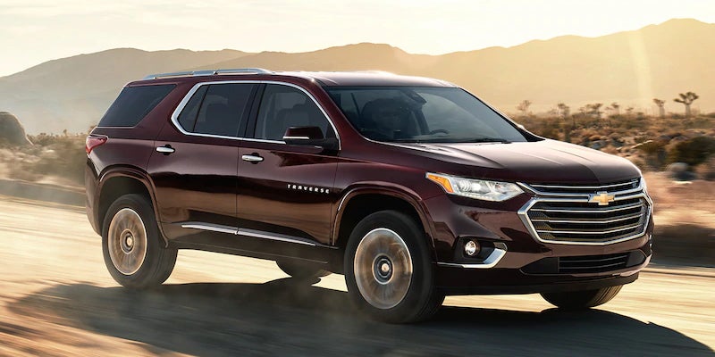 2021 Chevrolet Traverse driving through a desert road at sunset