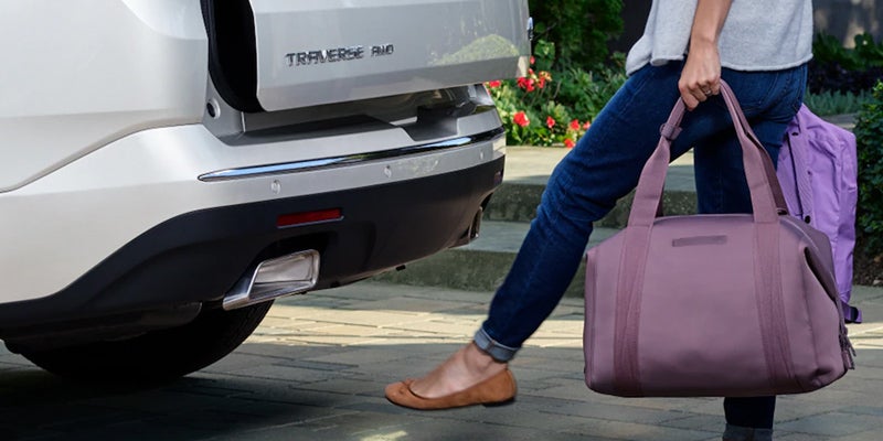 Hands-free liftgate activation by foot motion under the rear bumper of a white 2021 Traverse