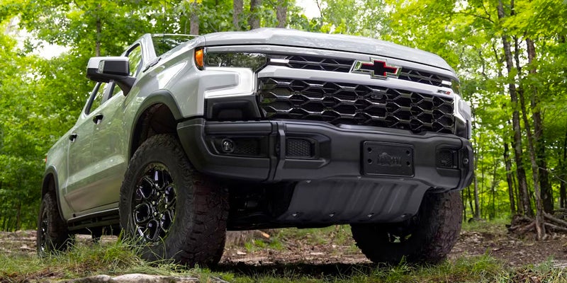 Low angle of a white 2024 Chevrolet Silverado 1500 in a wooded area