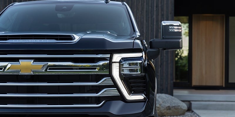 Front grille close-up of the 2024 Chevrolet Silverado HD with bold LED lighting and golden Chevrolet bowtie emblem.
