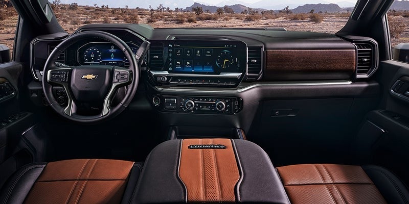 Luxurious dashboard and cockpit of the 2024 Chevrolet Silverado HD with dual digital displays and premium leather seating.