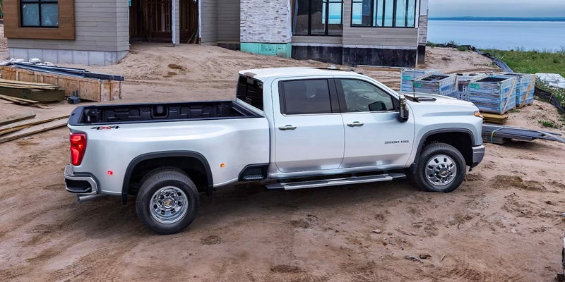 Side view of a white Chevrolet Silverado 3500 HD parked at a construction site