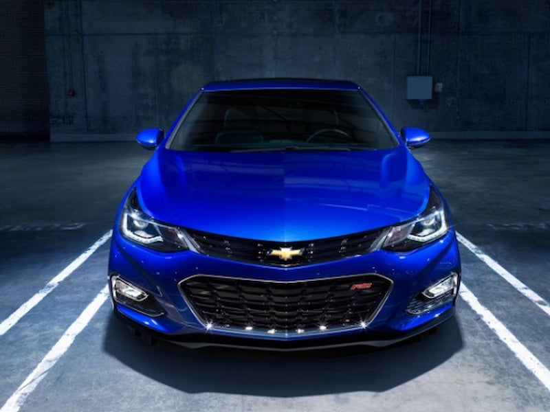 Front view of a blue 2017 Chevrolet Cruze RS parked in a dimly lit garage, showcasing the aggressive front grille and headlights